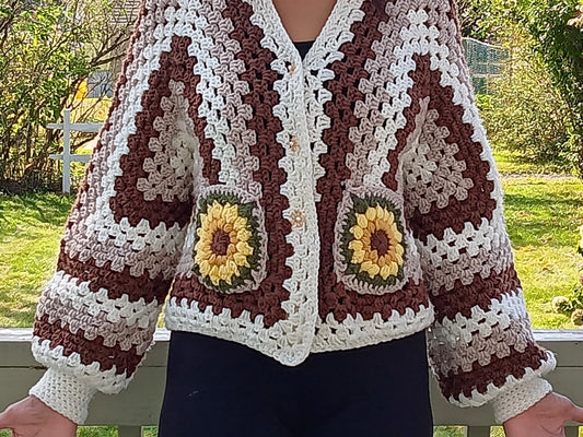 Kiera Monet crocheted jacket with flower design on the pockets, puffy sleeves and fitted cuff. 